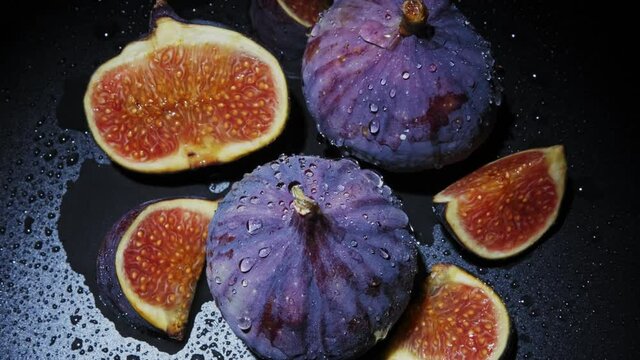 Beautiful blue violet Fresh figs on black background.