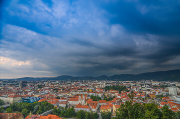 Obraz premium Storm with dramatic clouds over the city of Graz, with Mariahilfer church and historic buildings, in Styria region, Austria