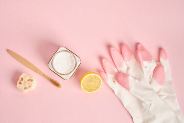 rubber gloves, loofah, soda, brush and lemon on pink background, cleaning with non-toxic...