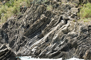 sharp rock layers at the coast of liguria in cinque terre north italy. Stone Texture background wallpaper