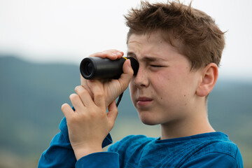 Young boy with monocular spy glass portrait.