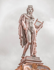 Apollo statue the ancient Greek god under cloudy sky, filtered image