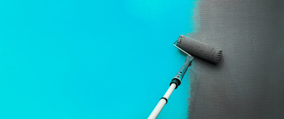 Close up roller with gray paint for painting walls. Repairs. Blue wall. Background. Screensaver for the site. High quality photo