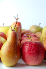 Pears and apples stand in rows on a white background.