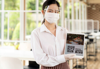 New Normal asian waitress hold qr code contactless menu tablet