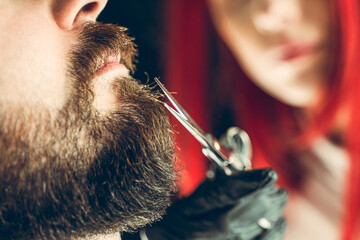 Visit to the barbershop. The master makes a beard cut with scissors