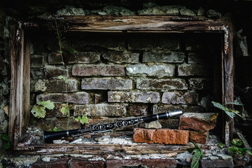 Old clarinet in frame of beautiful old broken brick wall. Music concept.