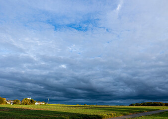 There are large and beautiful clouds over the green field