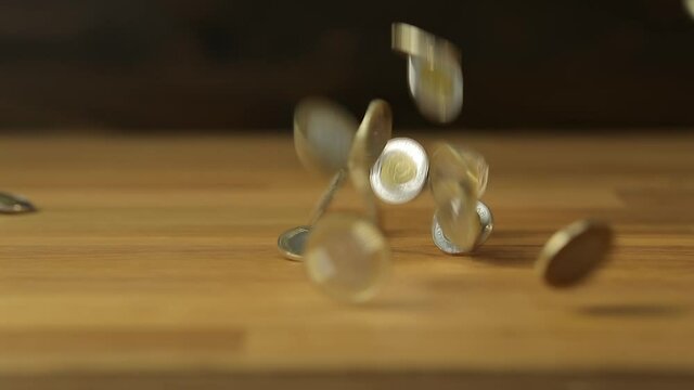 Coins falling in slow motion and hitting the ground. From 120 fps footage. Hungarian forints