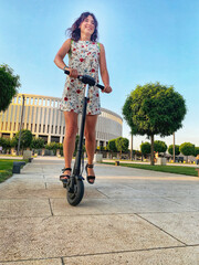 Beautiful young girl rides an electric scooter