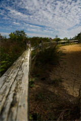 Beach fence with wispy clouds and sand at a beautiful location at Sandy Hook, New Jersey