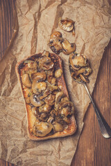 grilled ciabatta sandwich with mushrooms and feta cheese on a wooden board