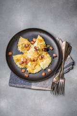 Dumplings with meat, onions and bacon on black plate. Traditional Polish dumplings