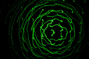 Abstract lines of green laser light on black background