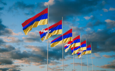 Waving flags of Nagorno-Karabakh Republic and Armenia agains sky background.