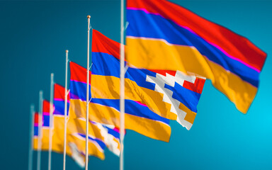 Several waving flags of Nagorno-Karabakh Republic and Armenia against sky background.