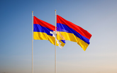 Two waving flag of Nagorno-Karabakh Republic and Armenia against sky background.