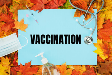 vaccination text on blue with fall leaves. Flu season or second wave. Face protective mask,...