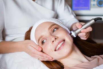 The red-haired girl on a cosmetic procedure. Hardware cosmetology. Skin care. Youthful skin