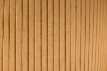Close-up of an orange and lit fabric surface. Vertical striped pattern. Abstract high resolution full frame textured background. Shallow depth of field.