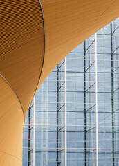 Abstract and modern wall made of spruce tree's wood boards and glass and steel facade of a modern...