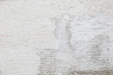 Aged and weathered brick wall, plastered and painted in white. Front view. High resolution full frame textured background. Copy space.