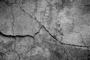 Obraz premium Close-up of cracked and weathered cement wall in black and white. Front view. High resolution full frame textured background.