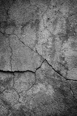 Close-up of cracked and weathered cement wall in black and white. Front view. High resolution full frame textured background.
