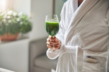 Male hand holding glass of fresh green smoothie