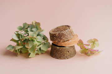 hand-made solid dry shampoos of a round shape on a plain beige background. natural hair cosmetics. soap for handicraft from chamomile and eucalyptus. environmentally friendly products, no waste