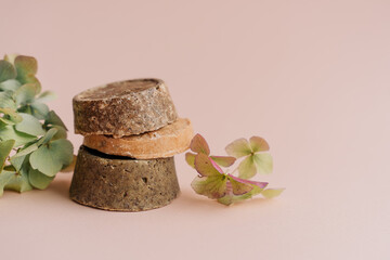 hand-made solid dry shampoos of a round shape on a plain beige background. natural hair cosmetics. soap for handicraft from chamomile and eucalyptus. environmentally friendly products, no waste