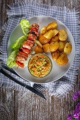 Shish kebab served with roasted potatoes and salad.