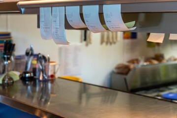 A chefs orders hang on the counter.