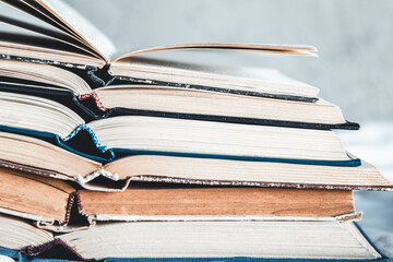 Opened books in a stack on a light home background. Education, hobbies