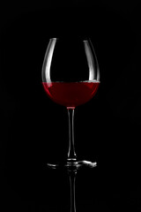 Wine glass with red wine isolated on black background