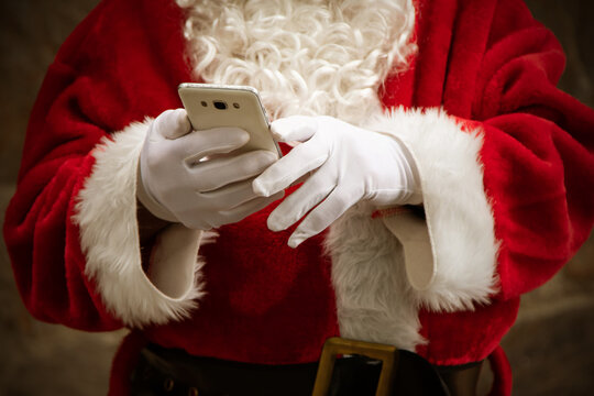 closeup of santa claus hands with mobile phone