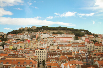 Fototapeta premium Building and roofs under a mountain in birds-eye-view in Lisbon.