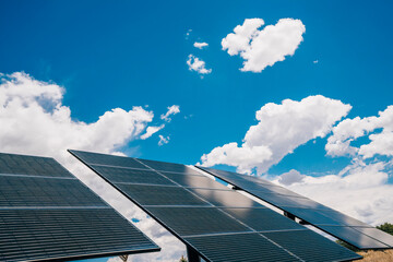 Solar panels in the desert with blue skies and puffy white clouds
