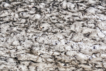 surface of a melting mountain glacier covered with stones and rubble