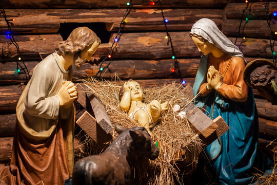 a reconstruction of birth of the savior (baby Jesus Christ), Joseph and Mary bent over the cradle with the infant, worship
