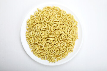 Indian snacks gathiya in white bowl in white background.