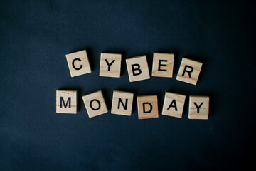 Obraz premium The inscription cyber monday from wooden blocks on a black background