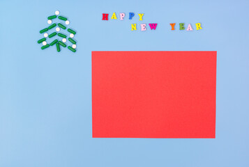 A Christmas tree made of green capsules and white pills and the inscription Happy new year on a blue background. The concept of holiday during the period of the pandemic. Congratulations