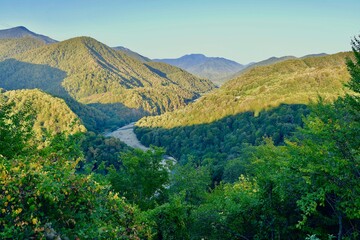 The Shakhe river among the mountains covered with forests, in the Lazarevsky district of Greater Sochi, at sunset

