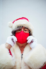 Obraz premium Santa Claus walking through the streets of the city of MadridSanta Claus putting on a mask in the city of Madrid.