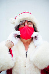 Obraz premium Santa Claus walking through the streets of the city of MadridSanta Claus putting on a mask in the city of Madrid.