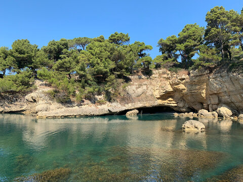 Picturesque rocky beach at Mediterranean coast. Sunny day. Turquoise surface on sea water. Blue laguna. Summer in Montenegro.