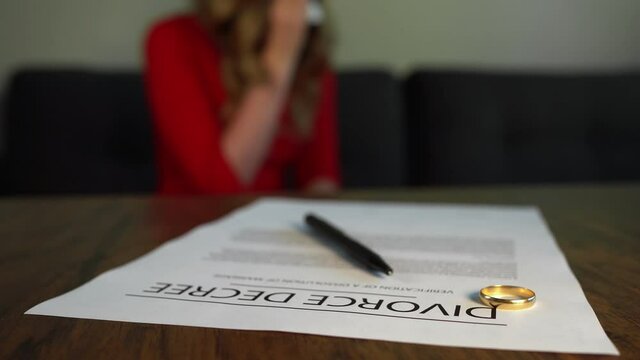 Divorce decree document. Woman is crying on the background.