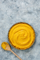 Cooking squash pie or pumpkin tart. Top view of crust and pumpkin filling. Autumn dessert.