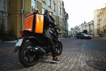 Man on motorbike with the dog inside special thermo bag for delivery food on the street.Food delivery service.